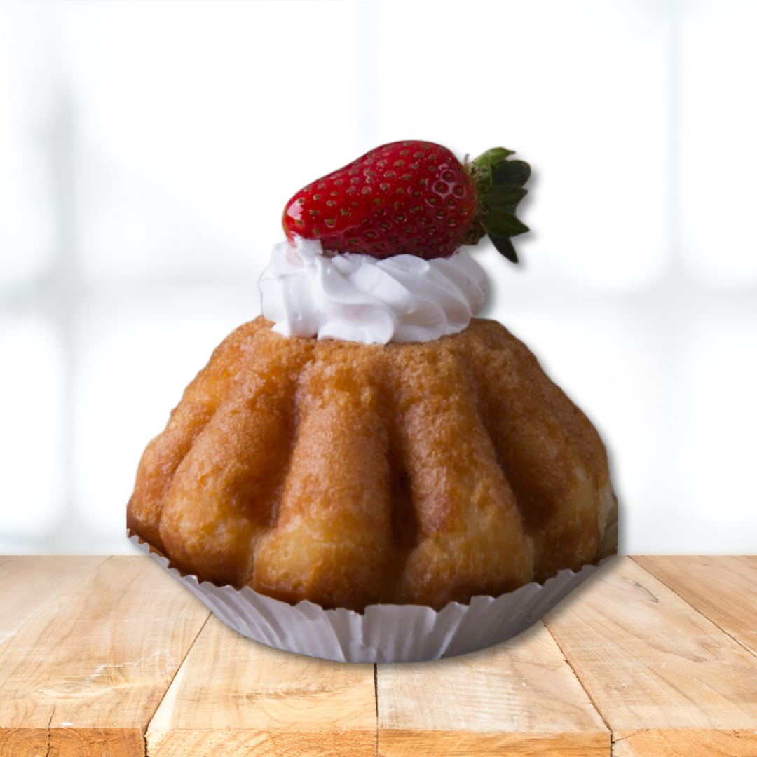 Baba rhum cake dessert topped with whipped cream and strawberry